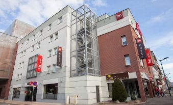 a tall building with a spiral staircase leading up to the second floor of it at Ibis Aéroport Bâle-Mulhouse