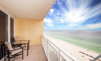 a balcony overlooking the ocean , with a dining table and chairs set up for a meal at The Bradford