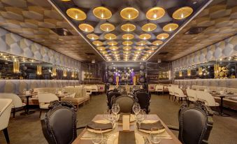 a modern restaurant with a dining area filled with tables , chairs , and a large circular light fixture at Hyatt Regency Grand Reserve Puerto Rico