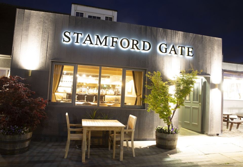 a dining area with a table and chairs , set up outside of the stamford gate store at Stamford Gate Hotel