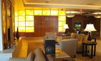 a hotel lobby with multiple couches , chairs , and tables , as well as a sign on the wall at The Inn at Charles Town / Hollywood Casino