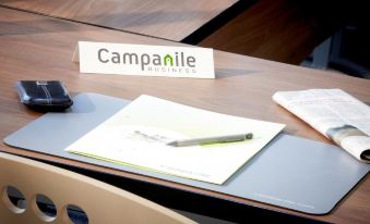 "a desk with a pen and a book , along with a sign that says "" campanile business ""." at Campanile Paris Est - Bobigny