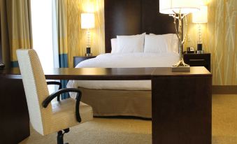 a hotel room with a large bed , two white pillows , and a desk with a lamp at Hampton Inn & Suites by Hilton Stroudsburg Pocono Mountains