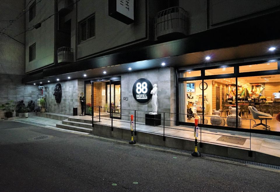 "a storefront of a clothing store with a sign that reads "" 8 8 "". the store appears to be busy , and several people" at Hotel 88 Shinsaibashi
