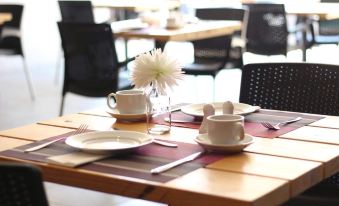 a dining room with a table set for breakfast , featuring a variety of dishes and utensils at Copperwood Hotel and Conferencing