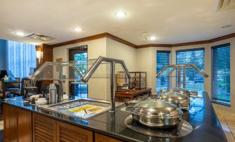 a large kitchen with a center island , stainless steel appliances , and a variety of pots and pans at Staybridge Suites Milwaukee Airport South