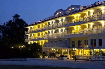 a large hotel building with multiple balconies lit up at night , creating a festive atmosphere at Hotel Summery