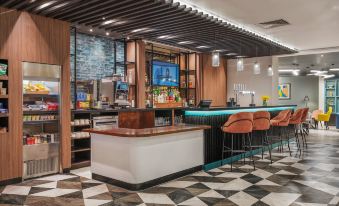 a modern restaurant with a bar area and a large screen tv , creating an inviting atmosphere for patrons at Holiday Inn Leeds - Wakefield M1, Jct.40