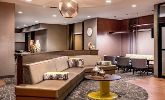 a modern hotel lobby with various seating options , including couches and chairs , and a bar area at SpringHill Suites Hershey Near the Park