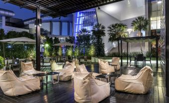 an outdoor dining area with a variety of chairs and couches arranged on a patio at Novotel Bangkok Impact