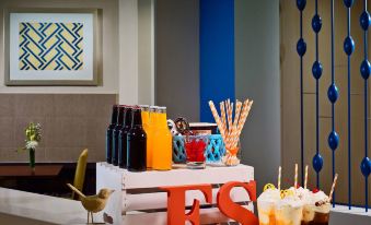 a dining table with a variety of food and drinks , including bottles and cups , as well as various snacks and desserts at Sonesta ES Suites San Francisco Airport San Bruno