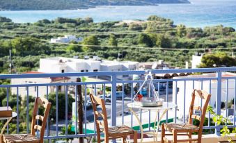 a balcony overlooking a beautiful view of the ocean , with a table and chairs on the balcony at Elpida Village