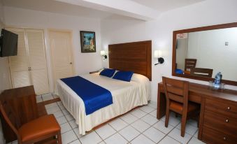 a hotel room with a blue and white bed , a wooden desk , and a chair at Hotel Marbella