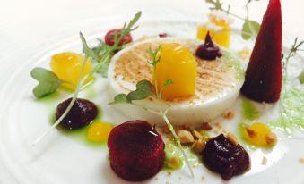 a white plate with a variety of food items on it , including a piece of meat at The Cuckoo Brow Inn