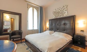 a large bed with white linens is situated in a room with a window and a mirror at Hotel Moderno
