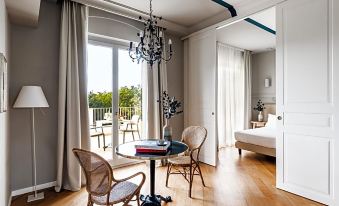 a modern , minimalist bedroom with wooden flooring and large windows , featuring a dining table , two chairs , and a bed at Seebay Hotel