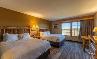 a hotel room with two beds , one on the left and one on the right side of the room at Grand Ely Lodge