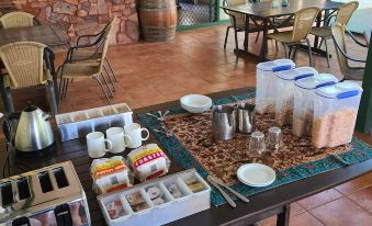 a dining table with a variety of breakfast items , including coffee and pastries , placed on it at Parry Creek Farm Tourist Resort & Caravan Park