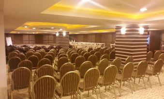 a large conference room with rows of chairs arranged in a semicircle , and a podium at the front of the room at Palm Wings Kusadasi Beach Resort&Spa