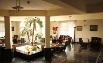 a spacious living room with a couch , chairs , and a dining table in the background at Park Hotel Bellevue