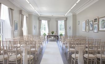 a white - walled room with rows of white chairs arranged in an orderly fashion , ready for an event at Eastwood Hall