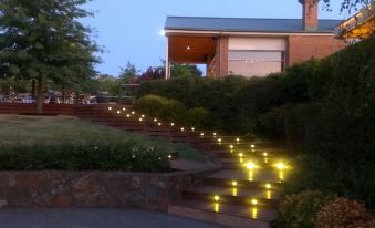 a brick house with yellow lights illuminating the stairs leading up to it , creating a serene and inviting atmosphere at Wild Cattle Creek Estate