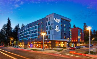 "a large building with a sign that says "" bb "" is surrounded by trees and street lights" at Aloft Seattle Redmond