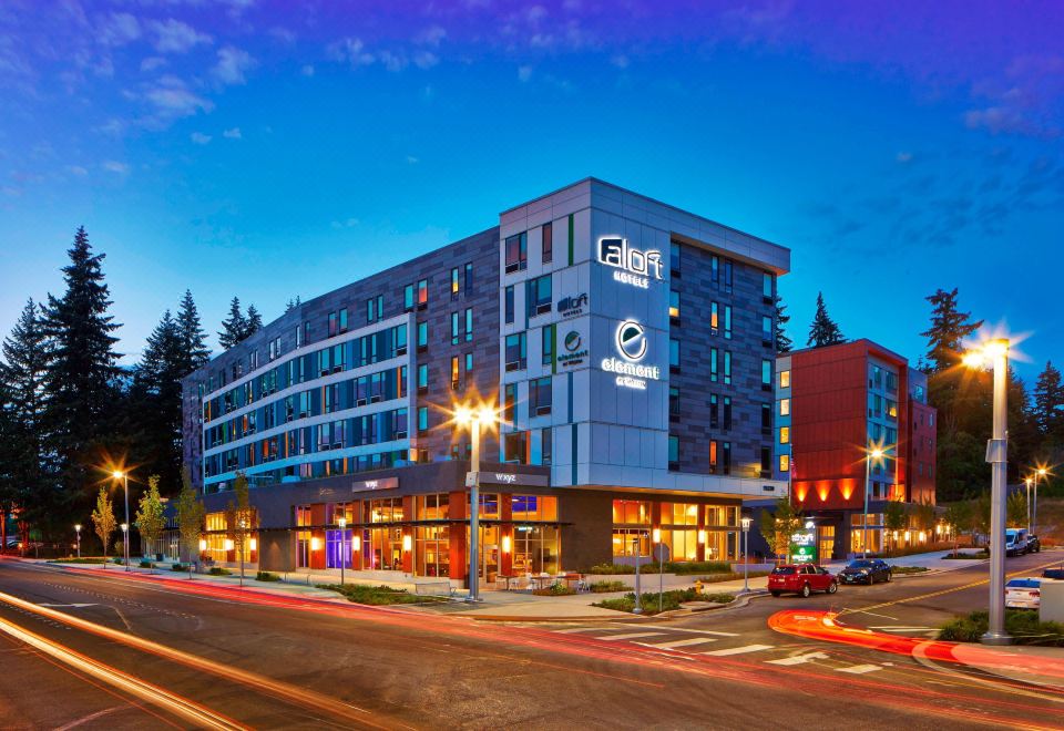 "a modern building with the word "" eone "" prominently displayed , surrounded by other buildings and a street at night" at Aloft Seattle Redmond
