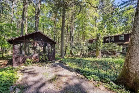 Rustic Rest Log Cabin, with hot tub and trout stream, near Poconos attractions.