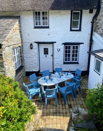 Charming  Listed Thatched Cottage with parking and short walk to sandy beach .
