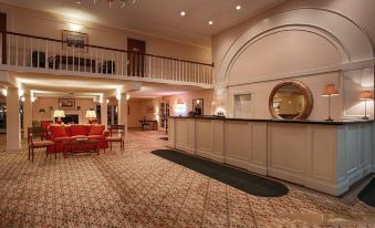 a hotel lobby with a reception desk , couches , and a staircase leading to the second floor at Best Western Plus Burley Inn  Convention Center