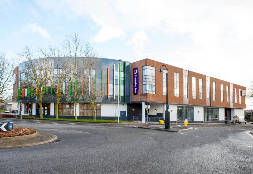 a modern building with a curved facade and large windows is located on a street corner at Premier Inn Trowbridge