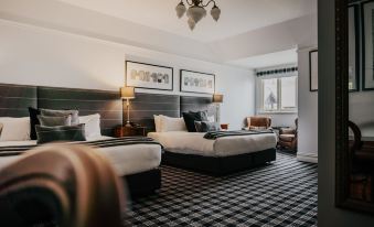 a hotel room with two beds , one on the left side and the other on the right side of the room at Hotel Bellinzona Daylesford