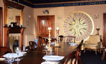 a long dining table set for a formal dinner , with multiple chairs arranged around it at Pool House