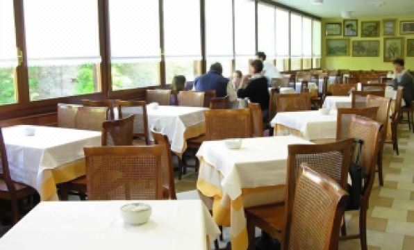 a restaurant with several tables and chairs , some of which are occupied by people enjoying their meals at Hotel Nazionale