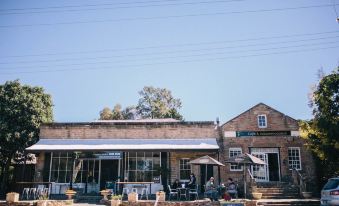 a brick building with a patio and several people sitting outside , enjoying the sunny day at Terroir Auburn