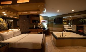 a large hotel room with two beds , a bathtub , and a television mounted on the wall at The Champagne Lodge & Luxury Suites