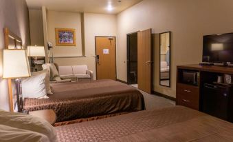a hotel room with two beds , a couch , and a tv . the room is well - appointed and clean at Newcastle Lodge & Convention Center