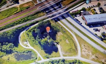 an aerial view of a rural area with a small red balloon floating in the sky at Paradiset