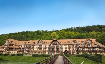 a long wooden bridge spanning a body of water , leading to a row of houses on a hillside at Club Wyndham Normandy