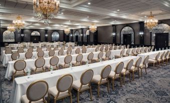 a large , empty banquet hall with rows of chairs and tables set up for an event at The Madison Hotel