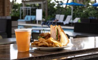 a plate of sandwiches and a drink are placed on a table next to a pool at Marriott's Oceana Palms