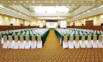 "a large conference room with rows of chairs and tables , a stage at the end , and the word "" goldman "" written on the screen" at Horison Ultima Bandung