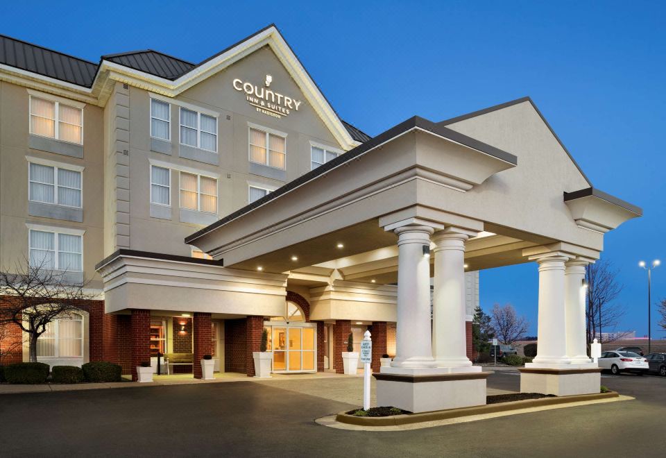 a large hotel with a hotel entrance and a logo on the front , indicating that it is a quality inn at Country Inn & Suites by Radisson, Evansville, IN