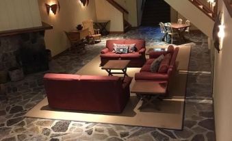 a large living room with a stone floor and various furniture , including couches and chairs at The Little Inn of Bayfield