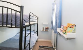 a small bedroom with two bunk beds , one on the left and one on the right side of the room at The Barn