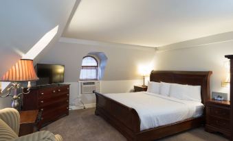 a well - decorated bedroom with a large bed , dresser , and flat - screen tv , along with the room 's interior design at Archer House