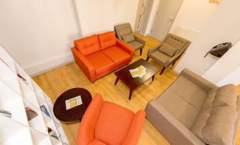 a living room with a variety of seating options , including couches , chairs , and a coffee table at YHA Blaxhall - Hostel