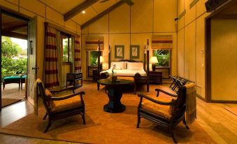 a cozy living room with two couches and a chair , creating a warm and inviting atmosphere at The Wakaya Club & Spa