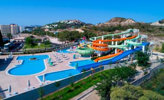 a water park with multiple water slides , a large pool , and a view of the mountains in the background at Amada Colossos Resort